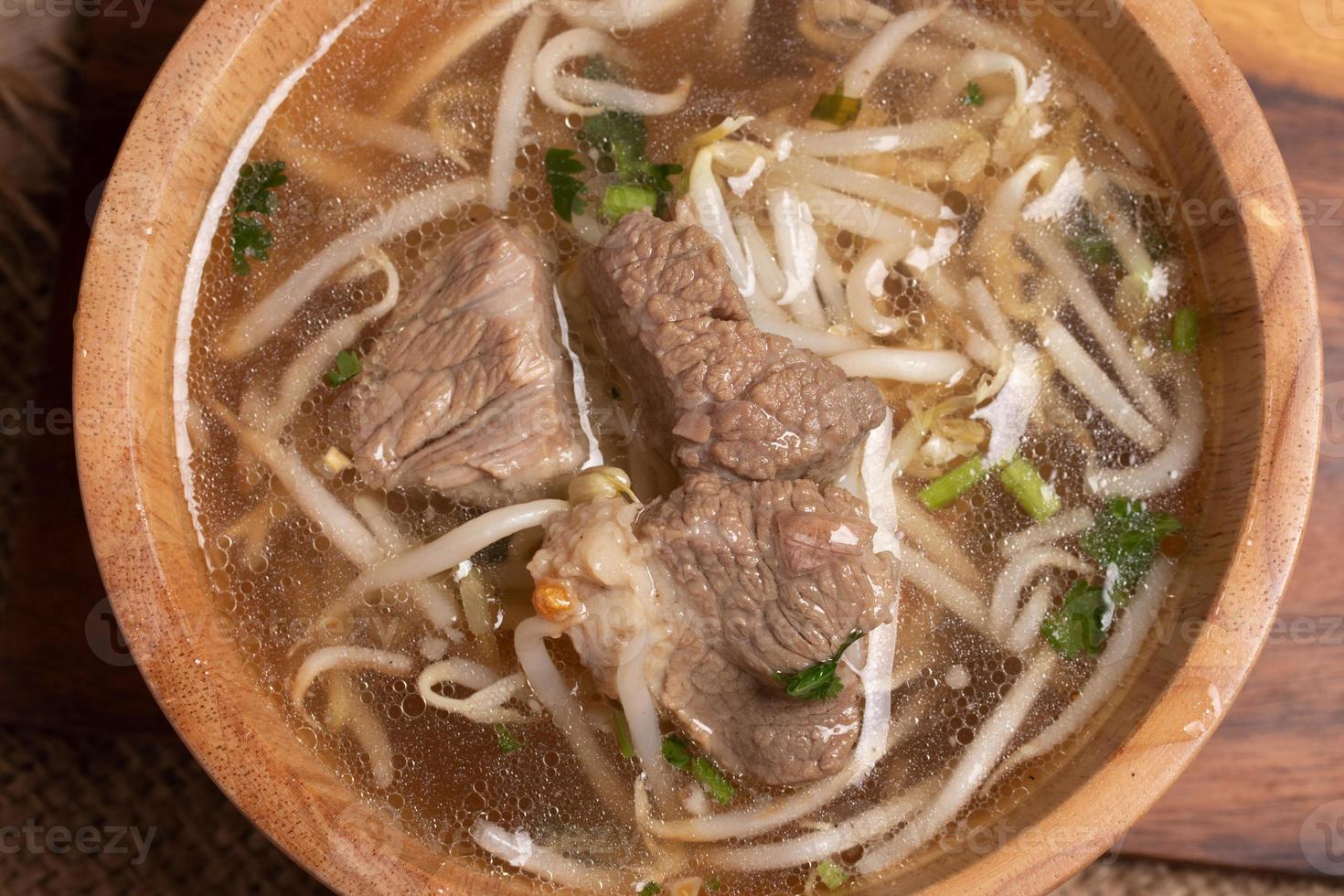 clear stewed pork soup in a wooden bowl photo