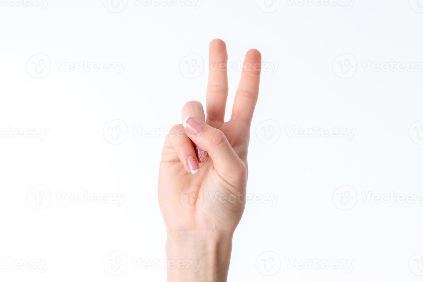female hand showing the gesture with raised up two fingers is isolated on a white background photo