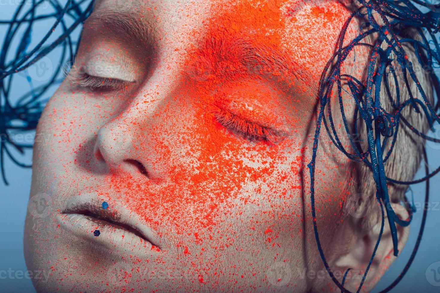 macro portrait of woman with neon powder on face photo