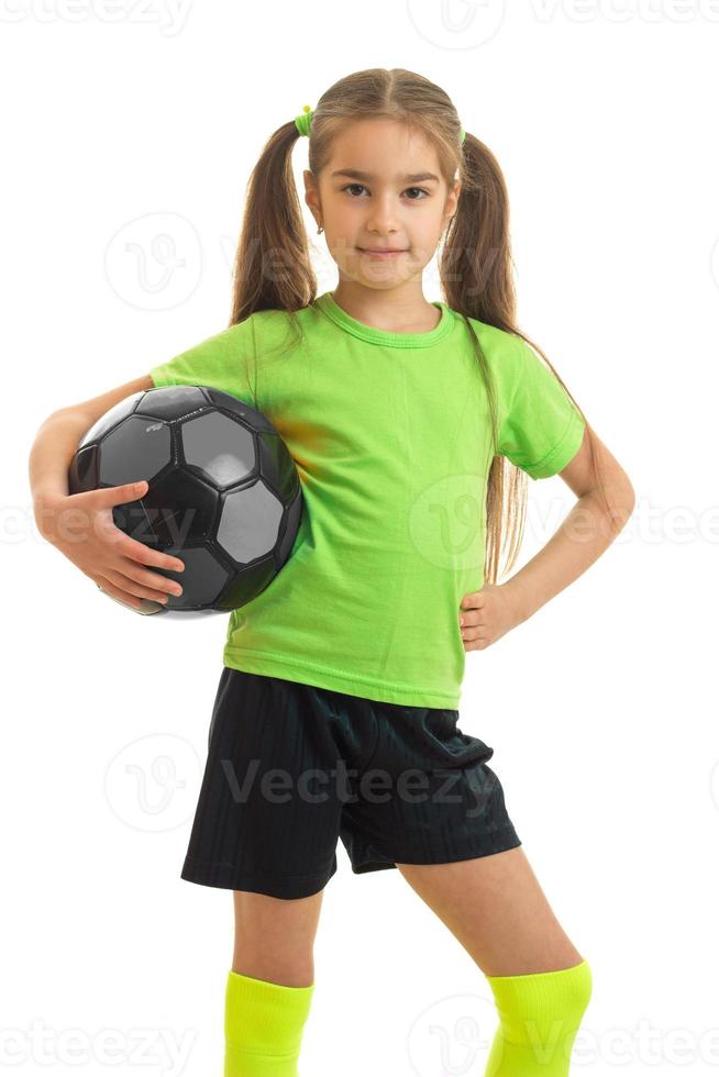 Charming young girl in green shirt with ball in hands photo
