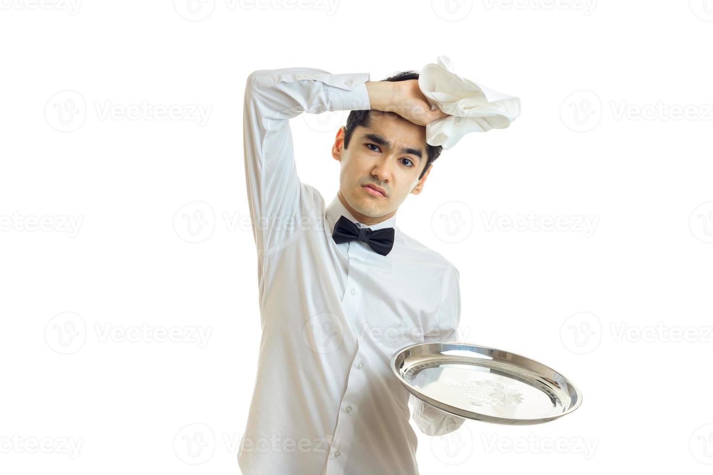 tired young brunette man in uniform with bowtie photo