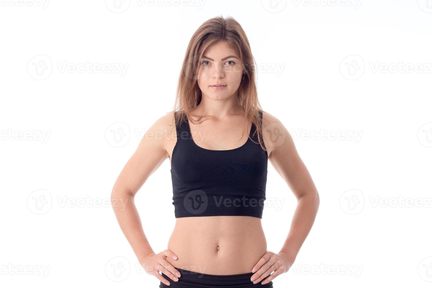 athletic girl in black top keeps his hands on the side photo