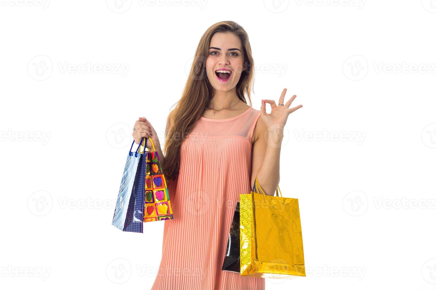 Merry girl holds many packages from stores isolated on white background photo