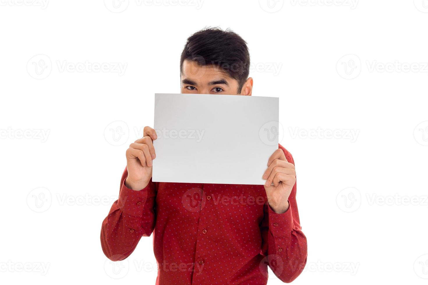 funny young brunette man in red t-shirt with placcard in his hands isolated on white background photo
