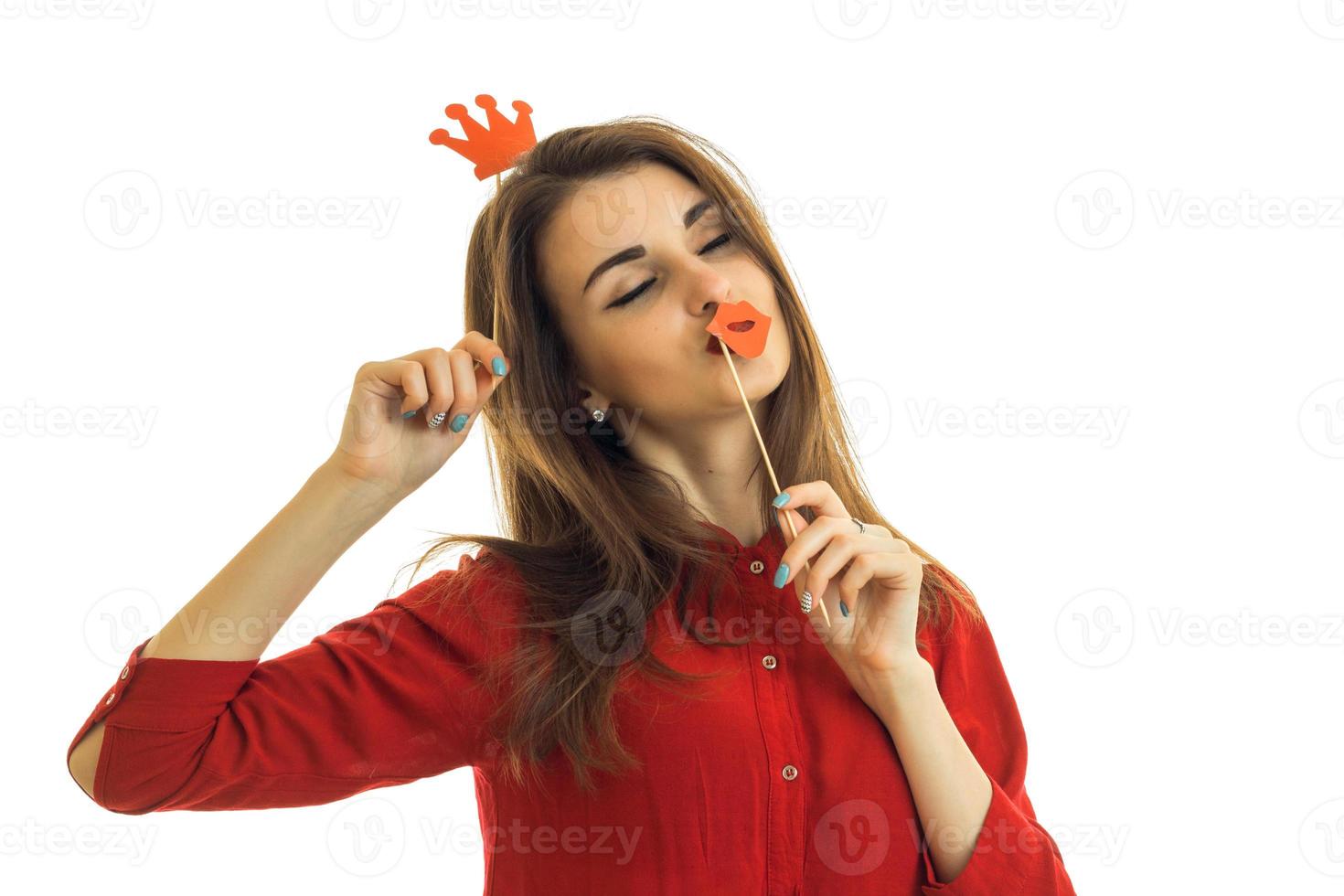 beautiful girl with dark hair is worth shutting your eyes and holding a paper Crown and a sponge photo