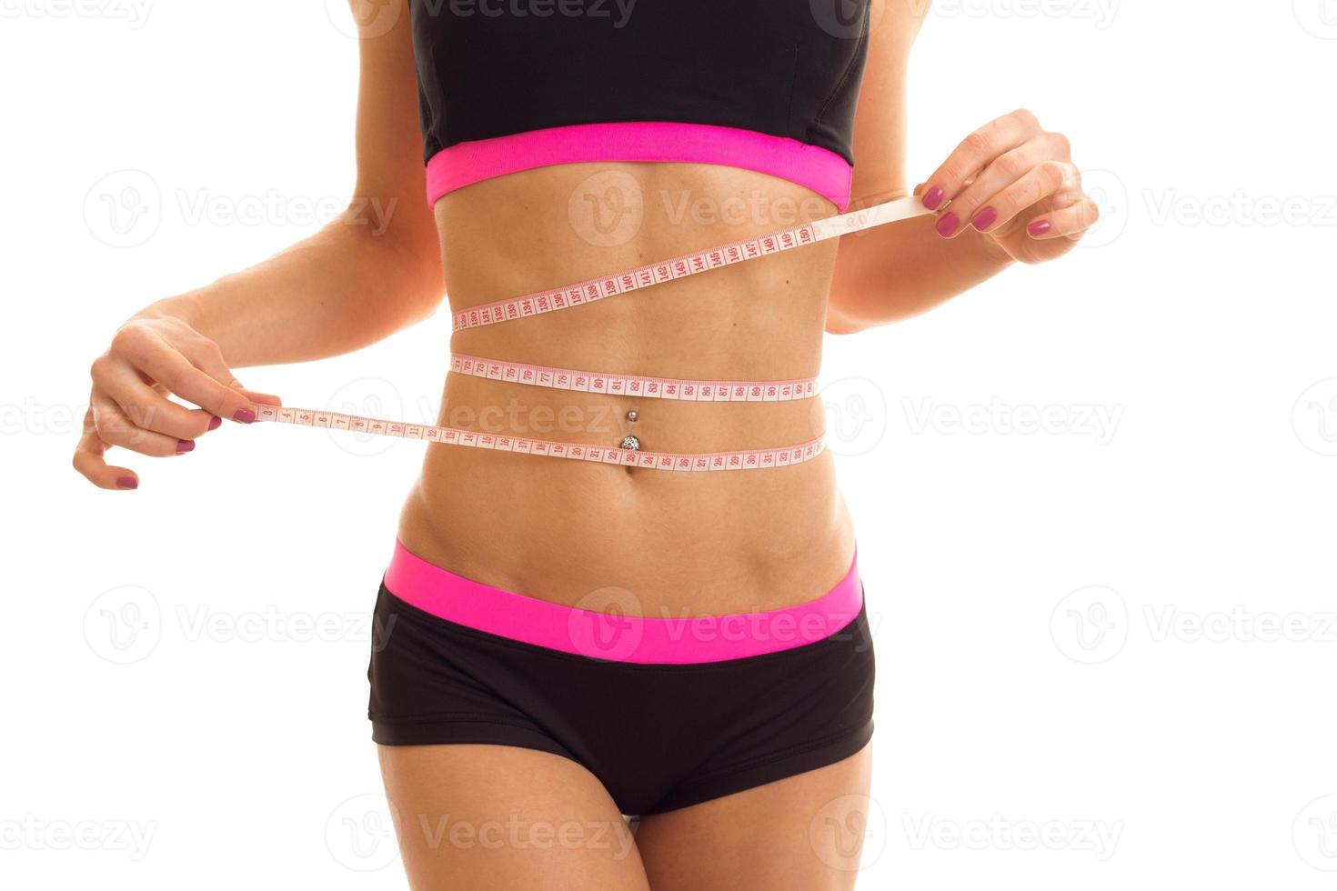 the girl merjae the waist using the measuring tape measures isolated on white background photo