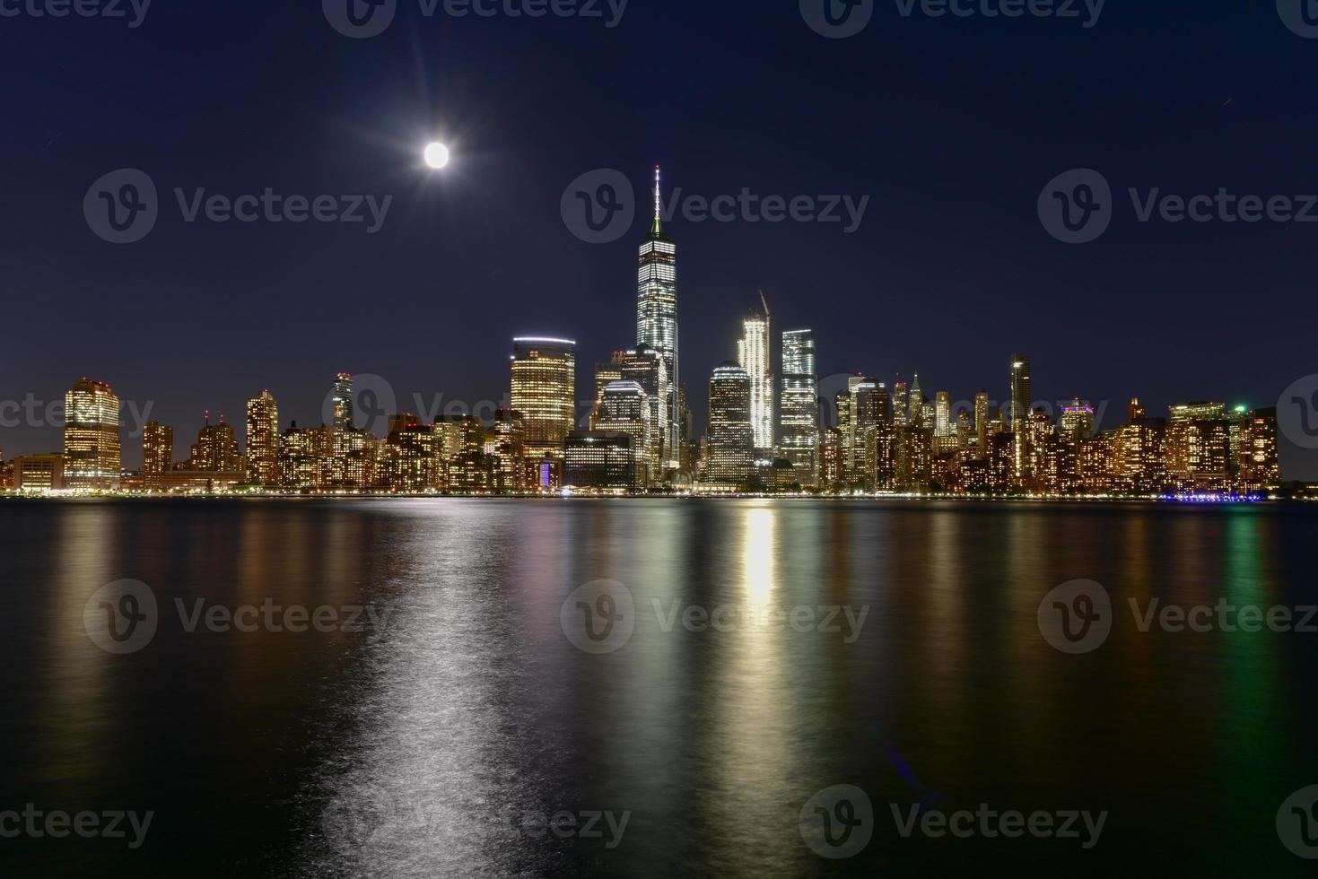 New York skyline as viewed across the Hudson River in New Jersey at dusk with the super moon in the background. photo