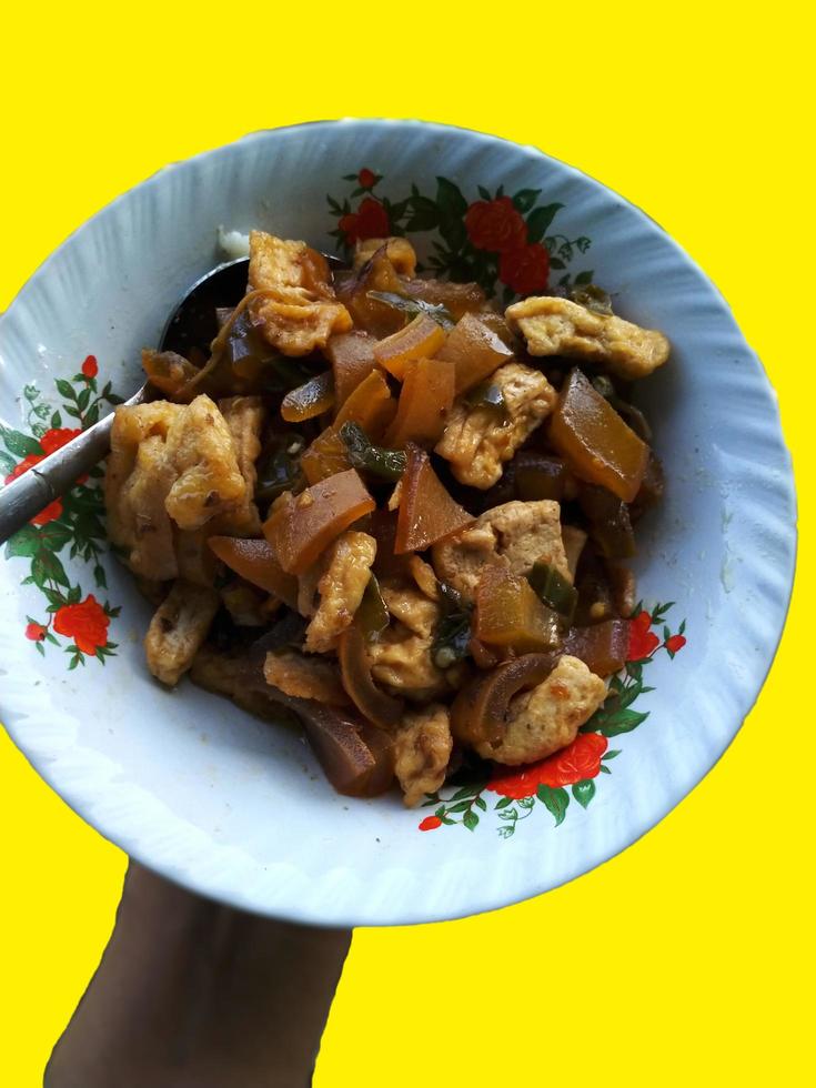 Indonesian typical cecek dish on a plate on a yellow background photo