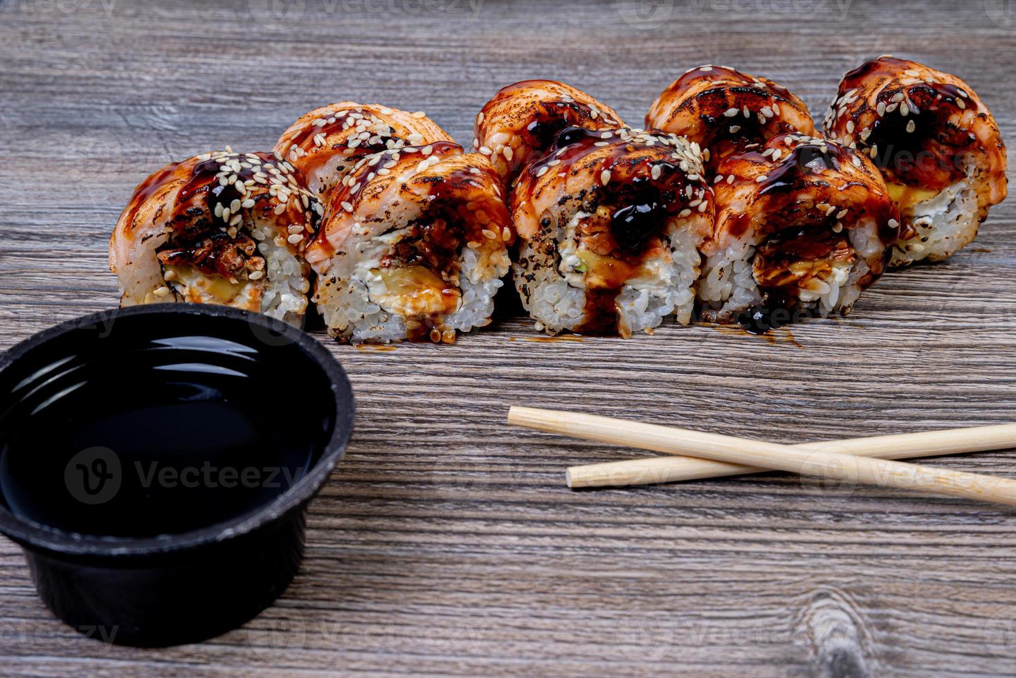 Traditional delicious fresh sushi roll set on a black background with reflection. Sushi roll with rice, cream cheese, avocado, salmon, sesame. Philadelphia. Sushi menu. Japanese kitchen, photo