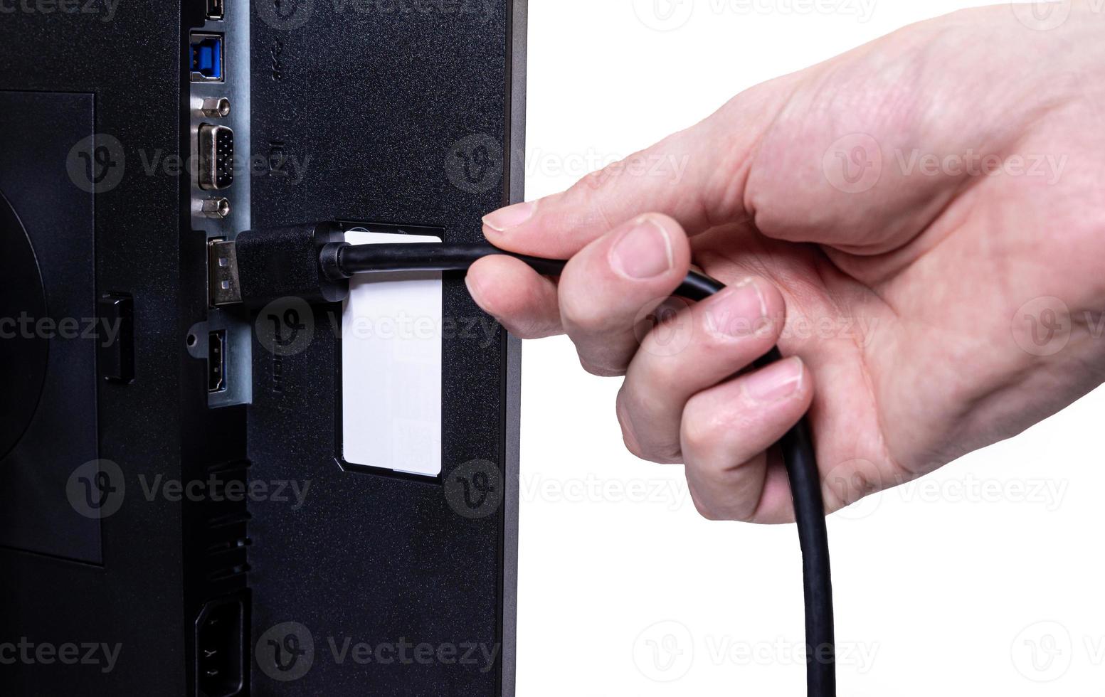 IT engineer Man hand inserts cable into monitor. Man hand connecting the DVI cable for monitor to computer PC. VGA DVI DisplayPort and power cable. close up in the hands of an . isolated photo