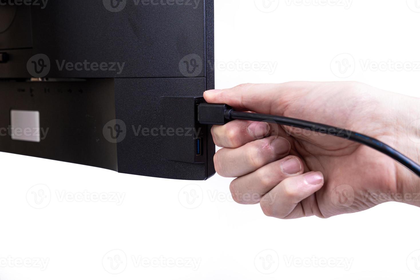 IT engineer Man hand inserts cable into monitor. Man hand connecting the DVI cable for monitor to computer PC. VGA DVI DisplayPort and power cable. close up in the hands of an . isolated photo