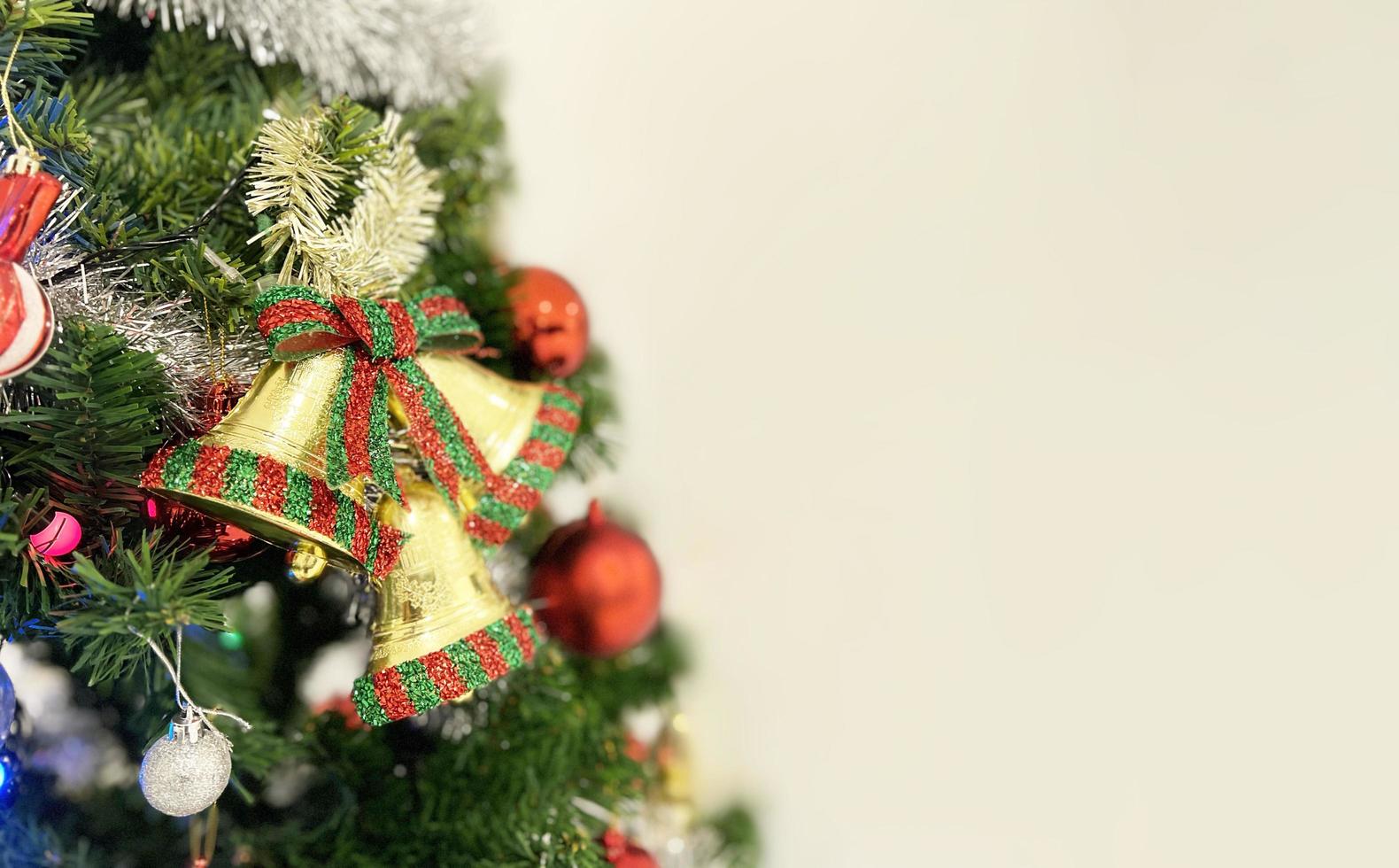 Árbol de Navidad decorado con caja de regalo de colores y campana aislado sobre fondo blanco. foto