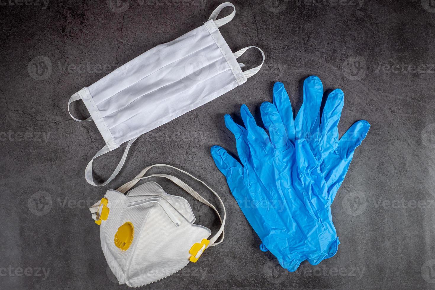 Protective medical mask, respirator and gloves on black background. Protective equipment against pollution, virus, flu and coronavirus, covid 19. photo