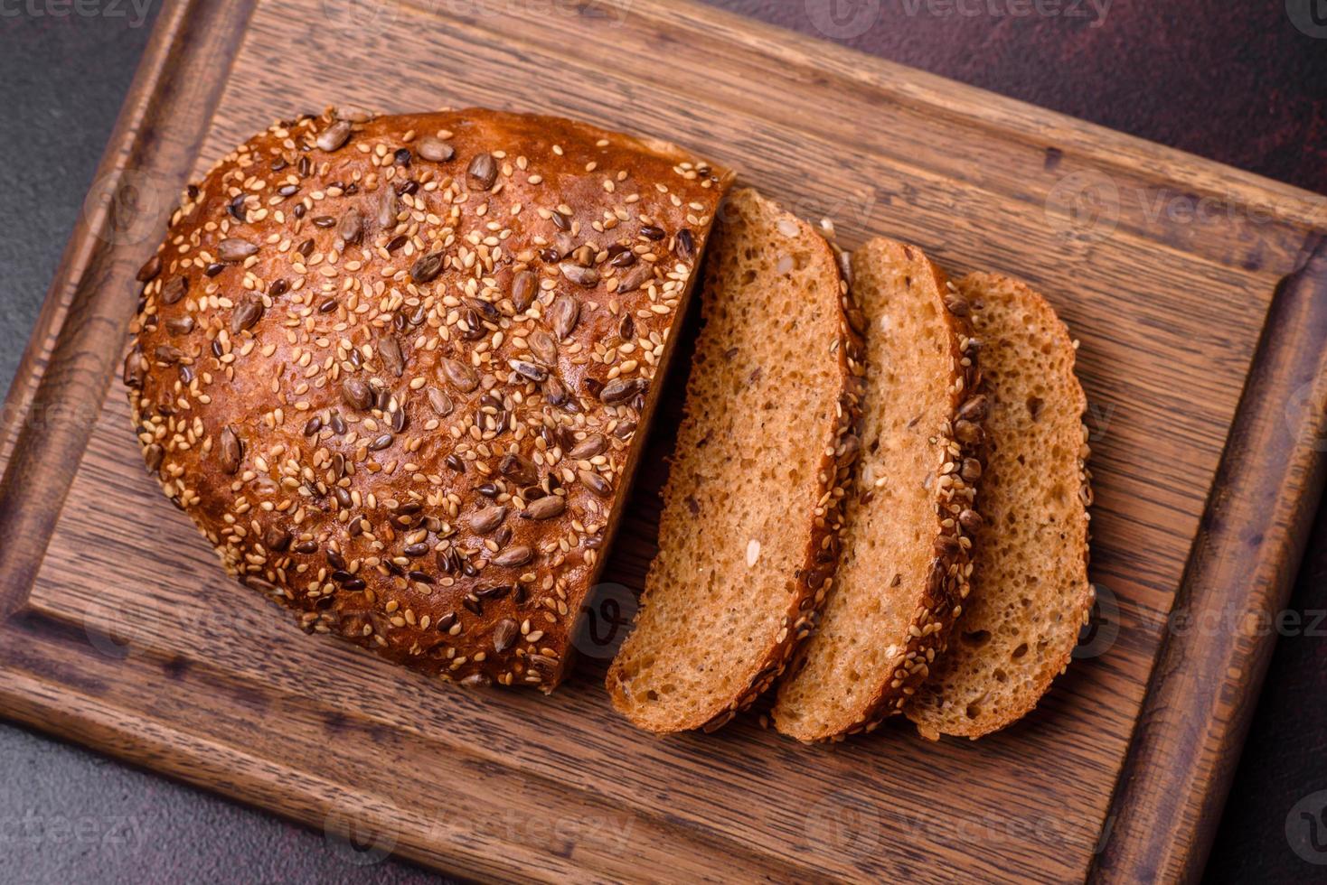 Delicious crispy bread with cereals on a wooden cutting board photo