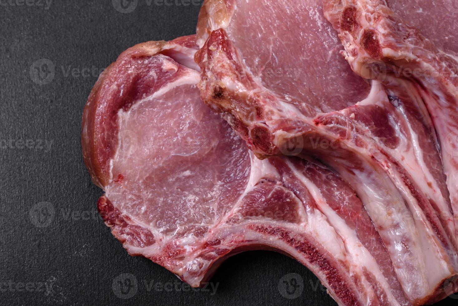 Fresh raw pork meat on the ribs with spices and herbs on a wooden cutting board photo