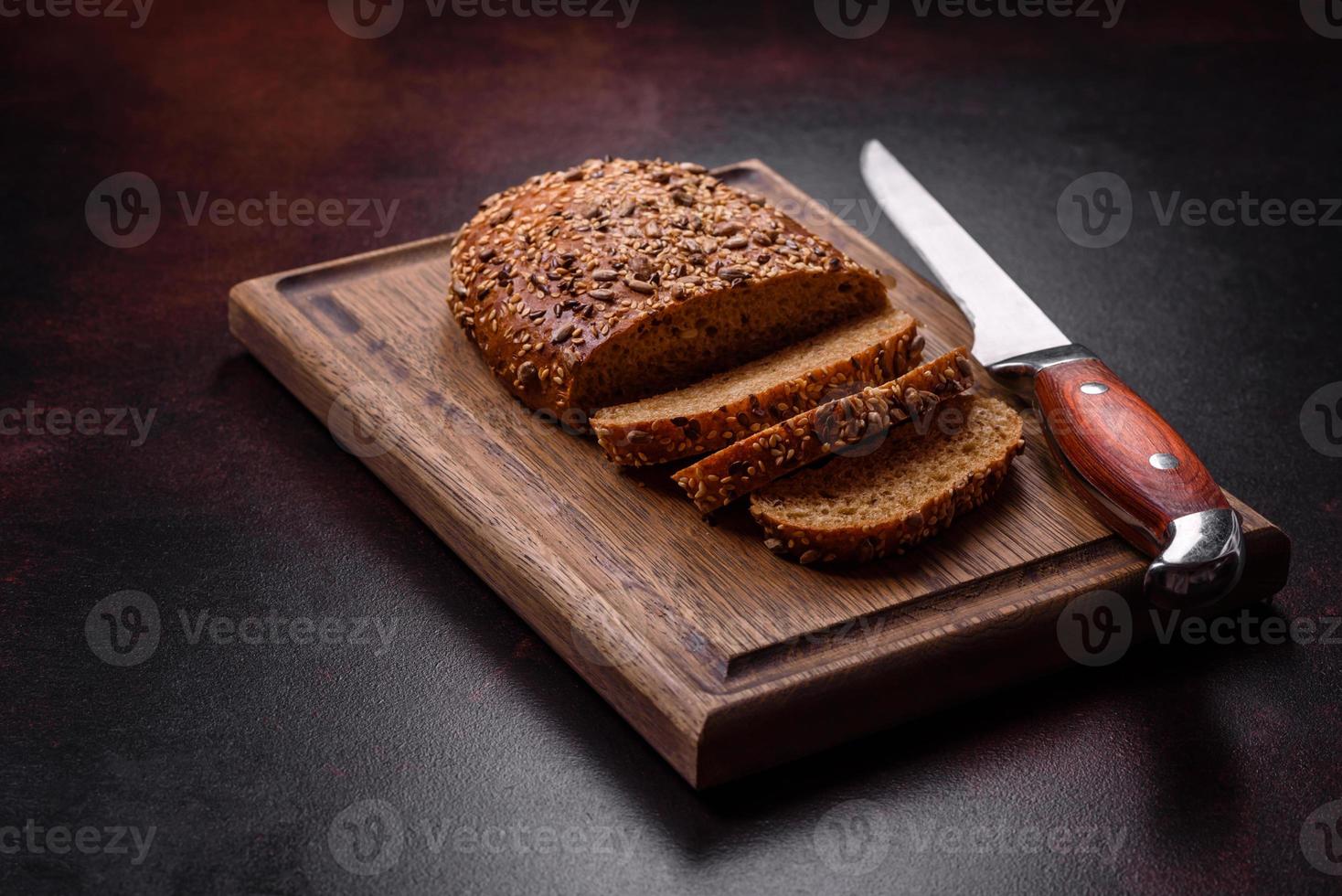 Delicious crispy bread with cereals on a wooden cutting board photo