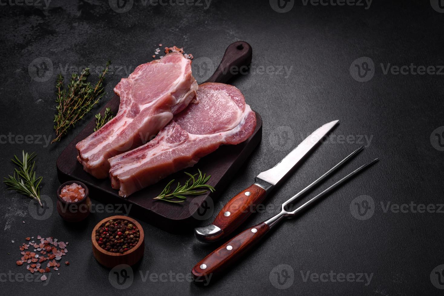 Fresh raw pork meat on the ribs with spices and herbs on a wooden cutting board photo