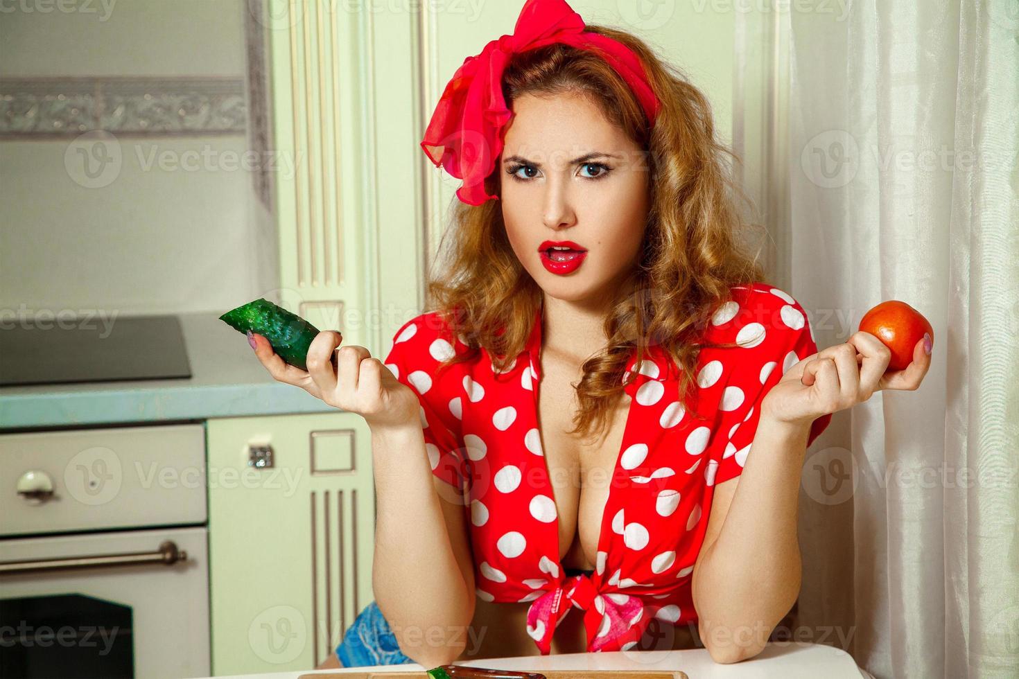 Portrait of beautiful woman in pinup tyle with cucumber and tomato in hands photo
