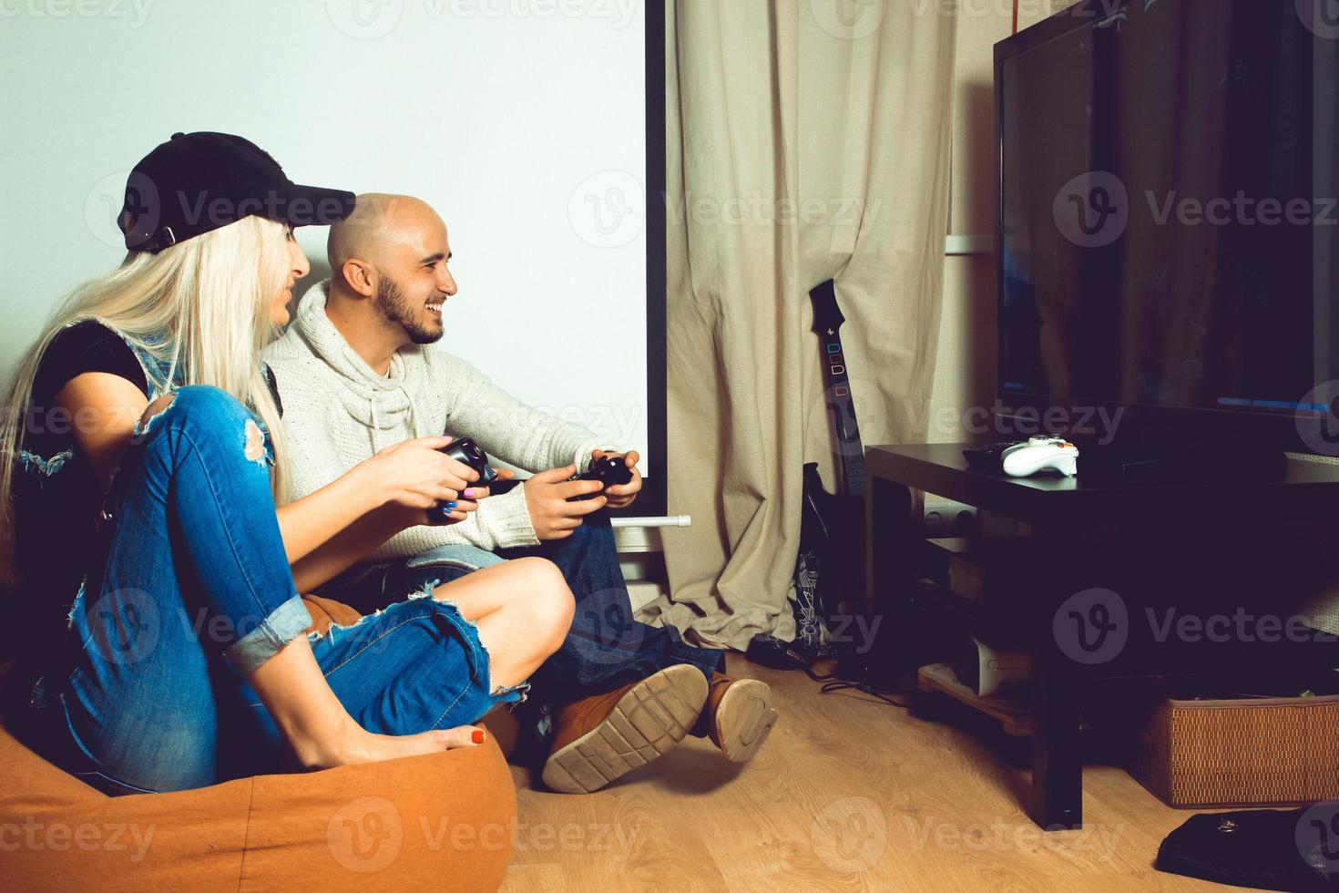 Beautiful young couple having fun and playing computer games photo