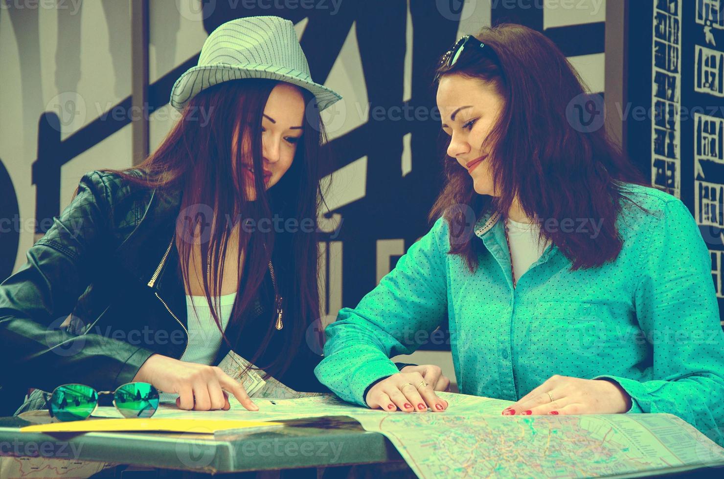 dos mujeres sentadas en una mesa en la calle foto