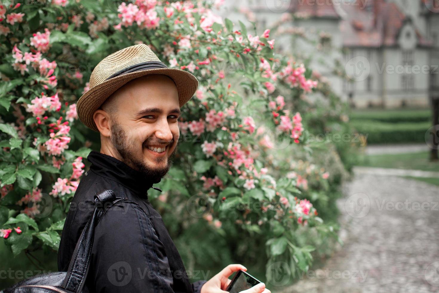 hombre con sombrero de paja y barba mirando a la cámara y sonriendo foto