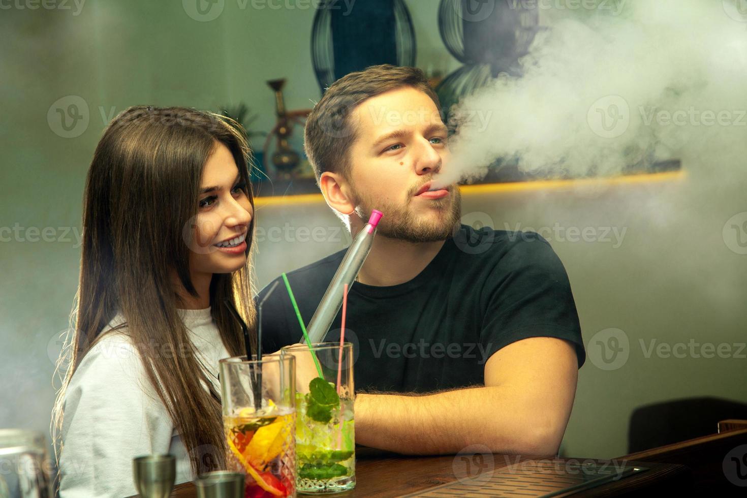 couple smokes shisha at the bar photo