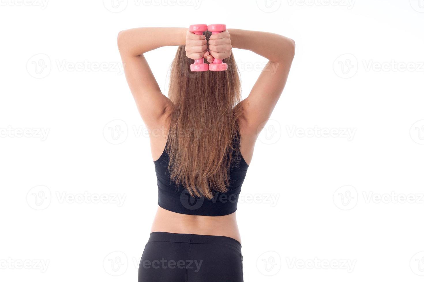 young girl holds  sports head over to little dumbbell isolated on white background photo