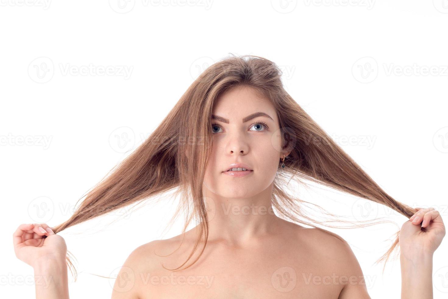 young girl without makeup keeps his hair with both hands isolated on white background photo