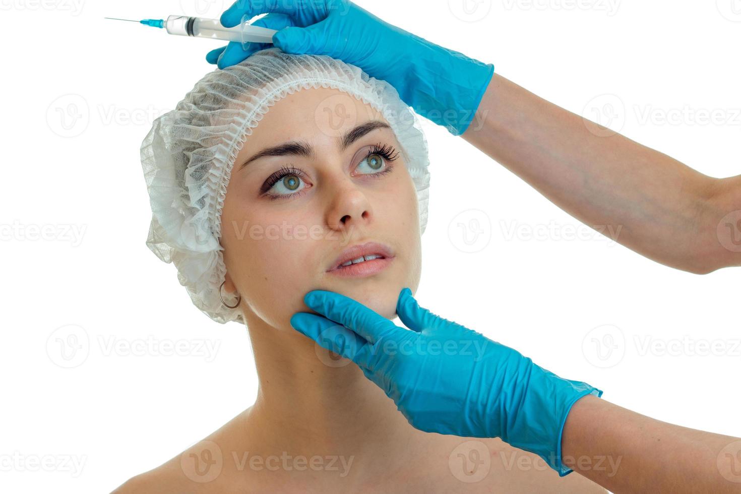young beautiful girl came to the face shine to the beautician who gloved examines her face close-up photo