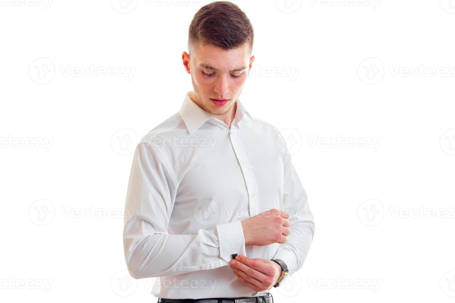 attractive young guy inserts into the sleeve cufflinks close-up photo