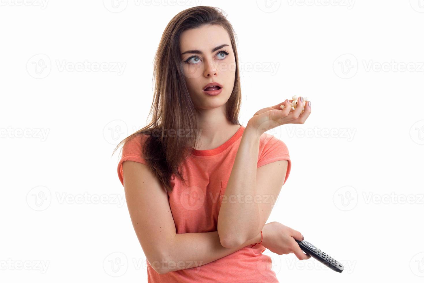 young beautiful thoughtful girl keeps the remote in hand and looks up photo
