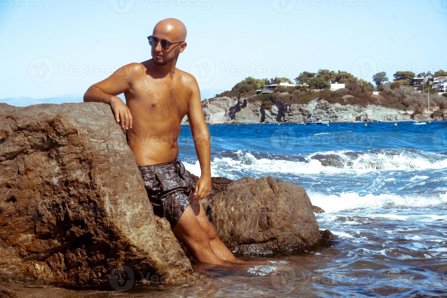 handsome man on the marine rocky shore photo