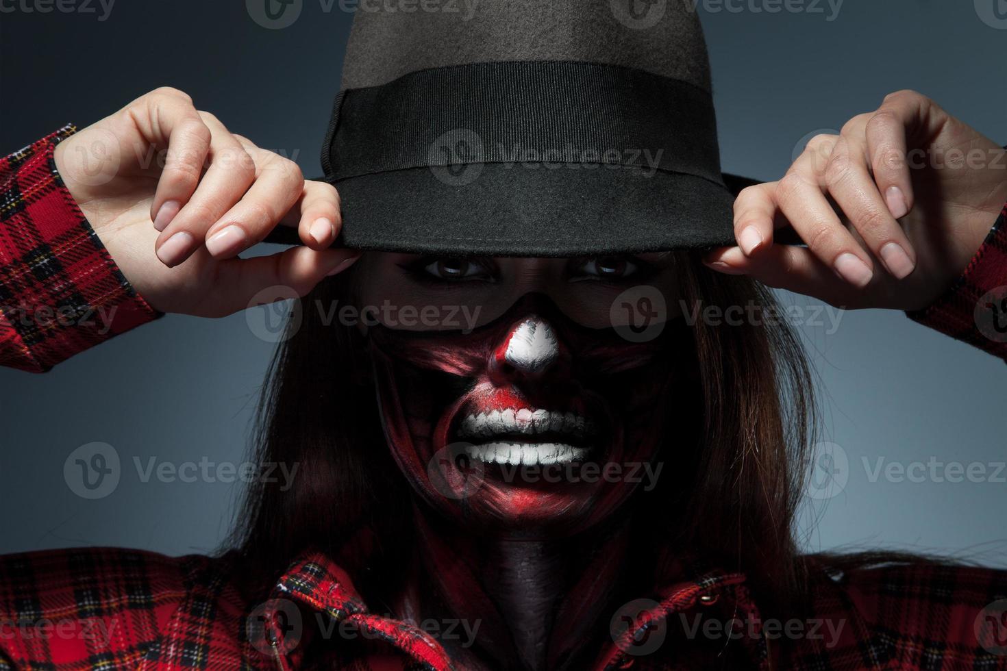 retrato horizontal de mujer con arte de cara aterradora para la noche de halloween mirando a la cámara foto