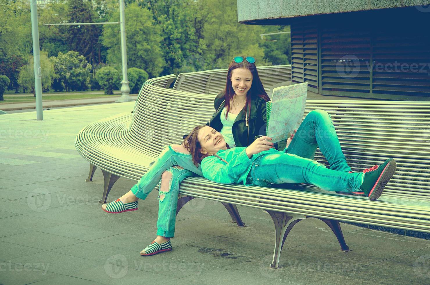 Girls resting on a bench photo