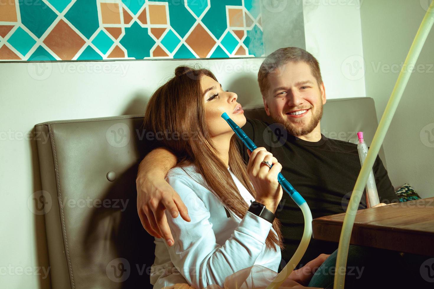 pareja fuma shisha en el bar hookah foto