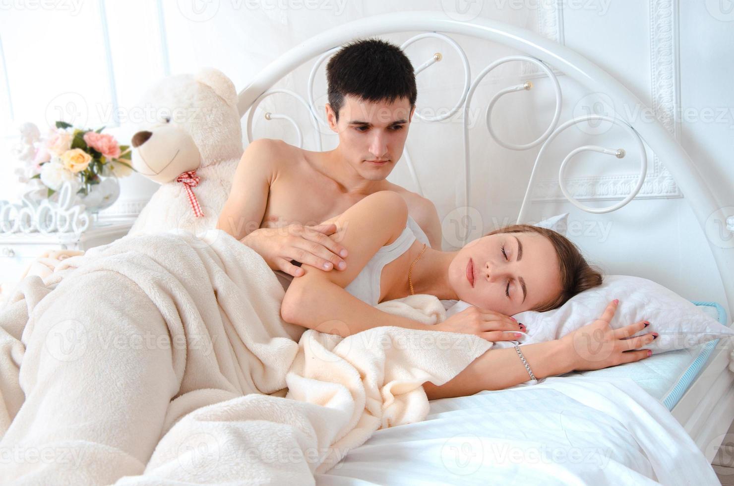 lovers lying on white bed photo