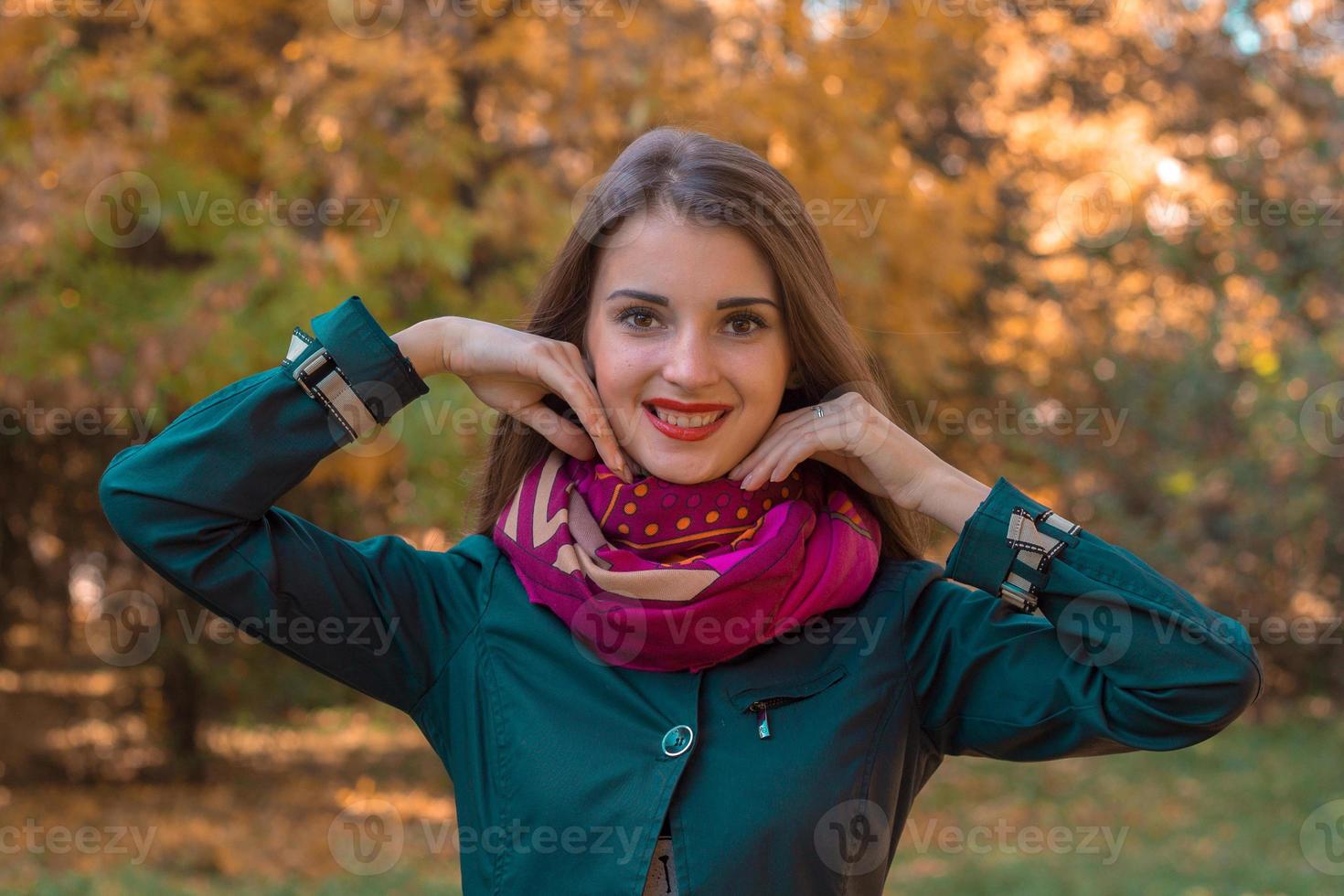 beautiful sweet girl looks into the camera and adjusts his scarf photo