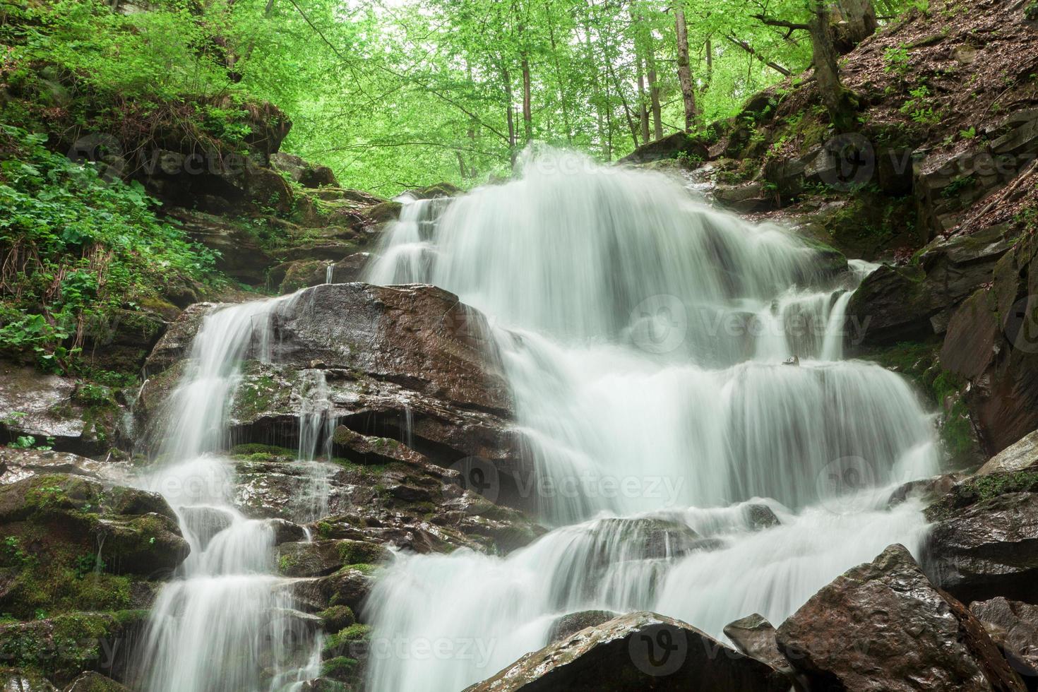 mountain waterfall with a rocky bottom photo