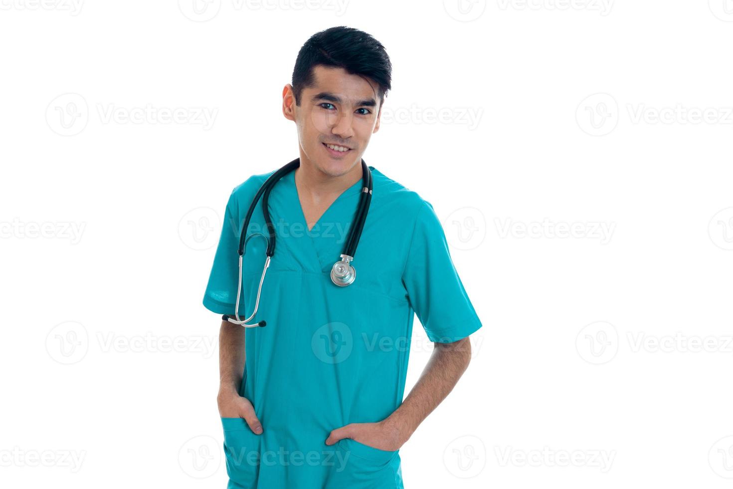 un joven médico con estetoscopio se para sobre los hombros y sonríe aislado de fondo blanco foto