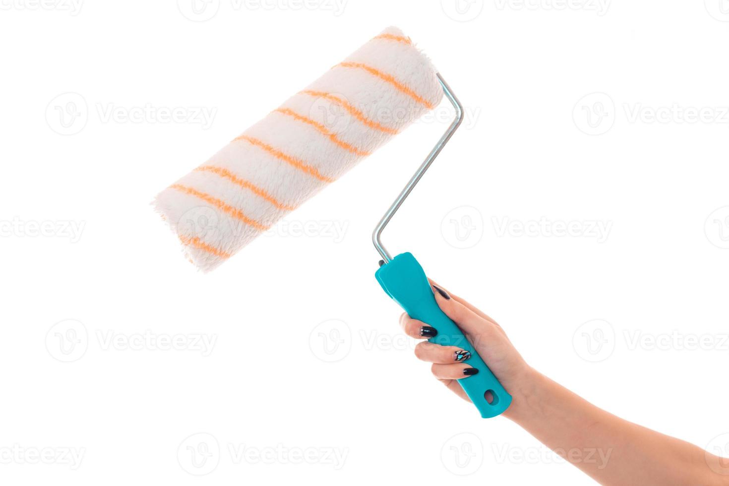 the outstretched arm with roller for painting walls isolated on white background photo