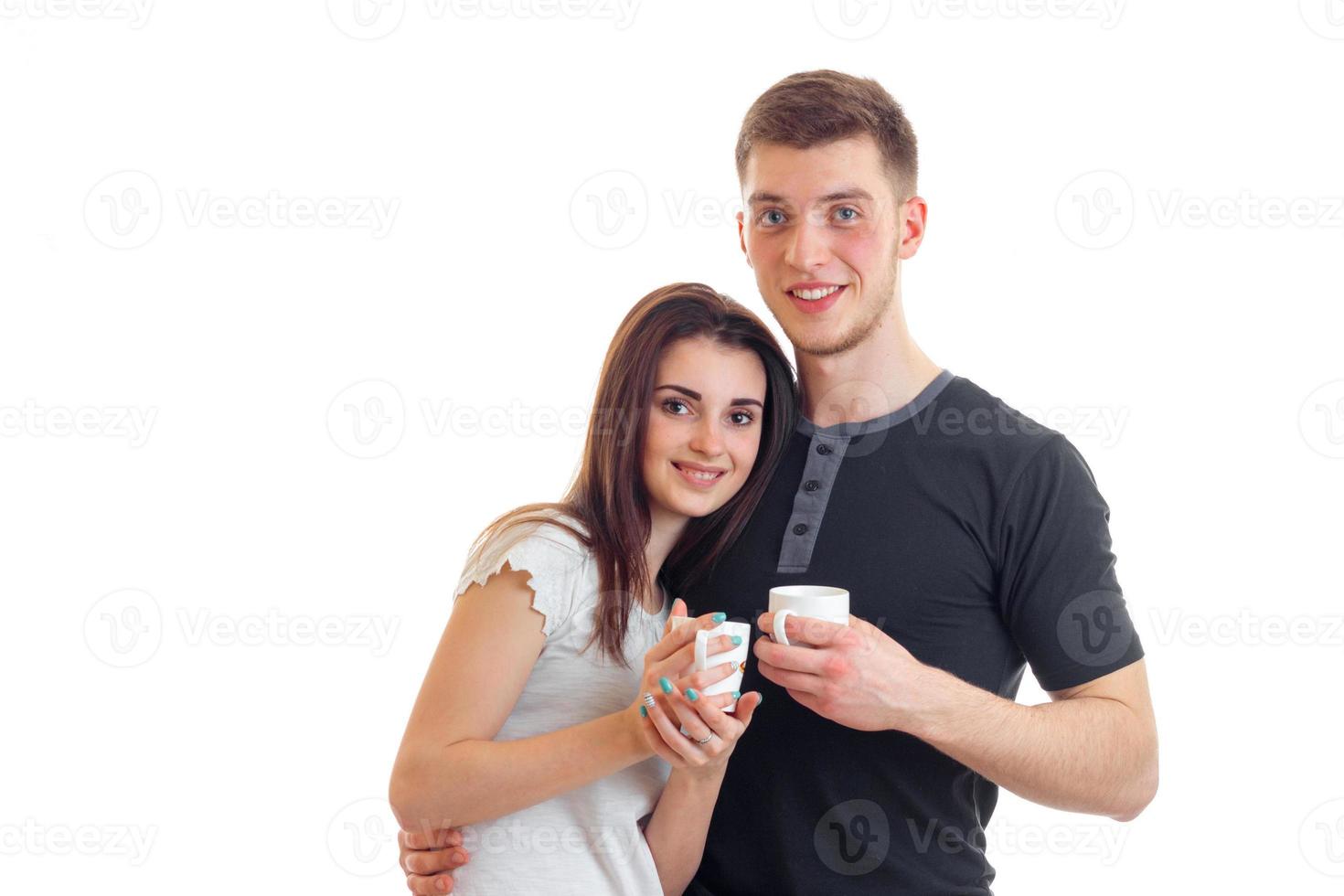 beautiful young couple smiling and holding a cup of tea photo