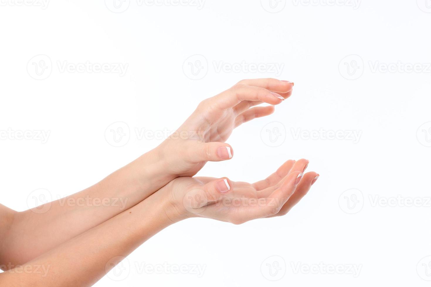 two women's hands are outstretched to the side and lying on top of one another with palms is isolated on a white background photo