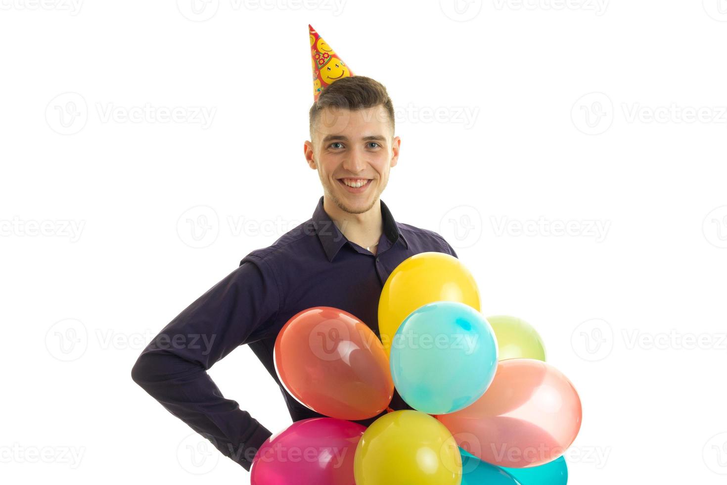 Jolly nice guy looks into the camera and holds in his hand a lot of colorful balloons photo