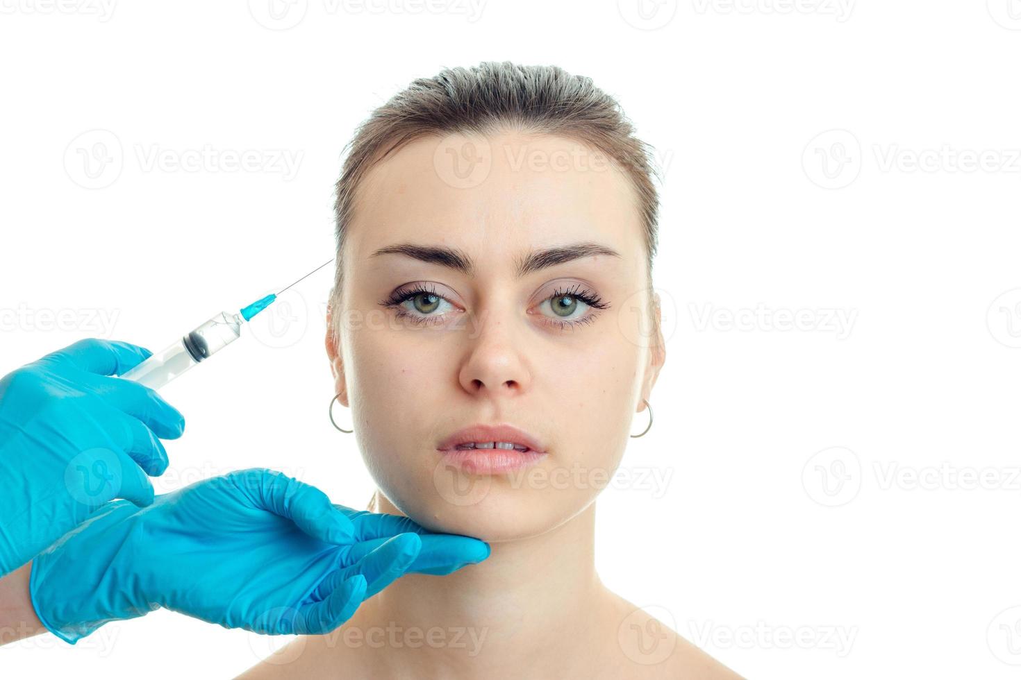 the doctor conducts injections in blue gloves on the face of a young girl have close-up photo