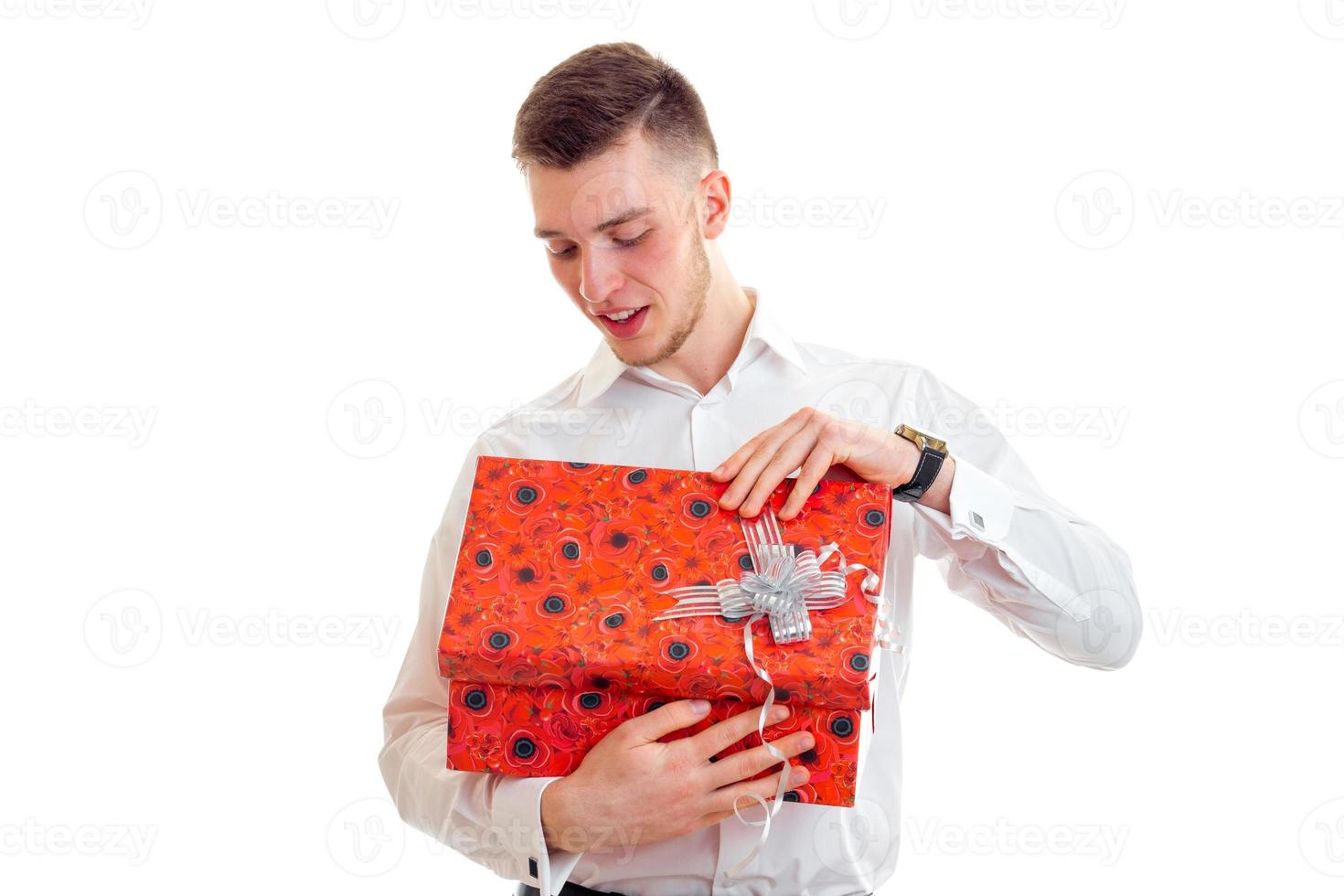 handsome young guy opens the gift in red box photo