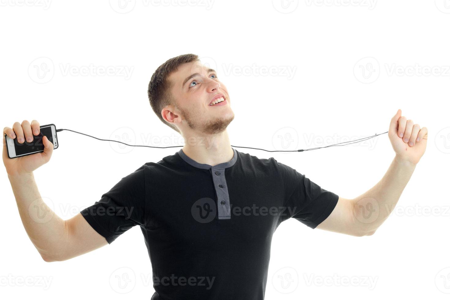 Cheerful young boy holding a mobile phone with headphones and smiling away photo