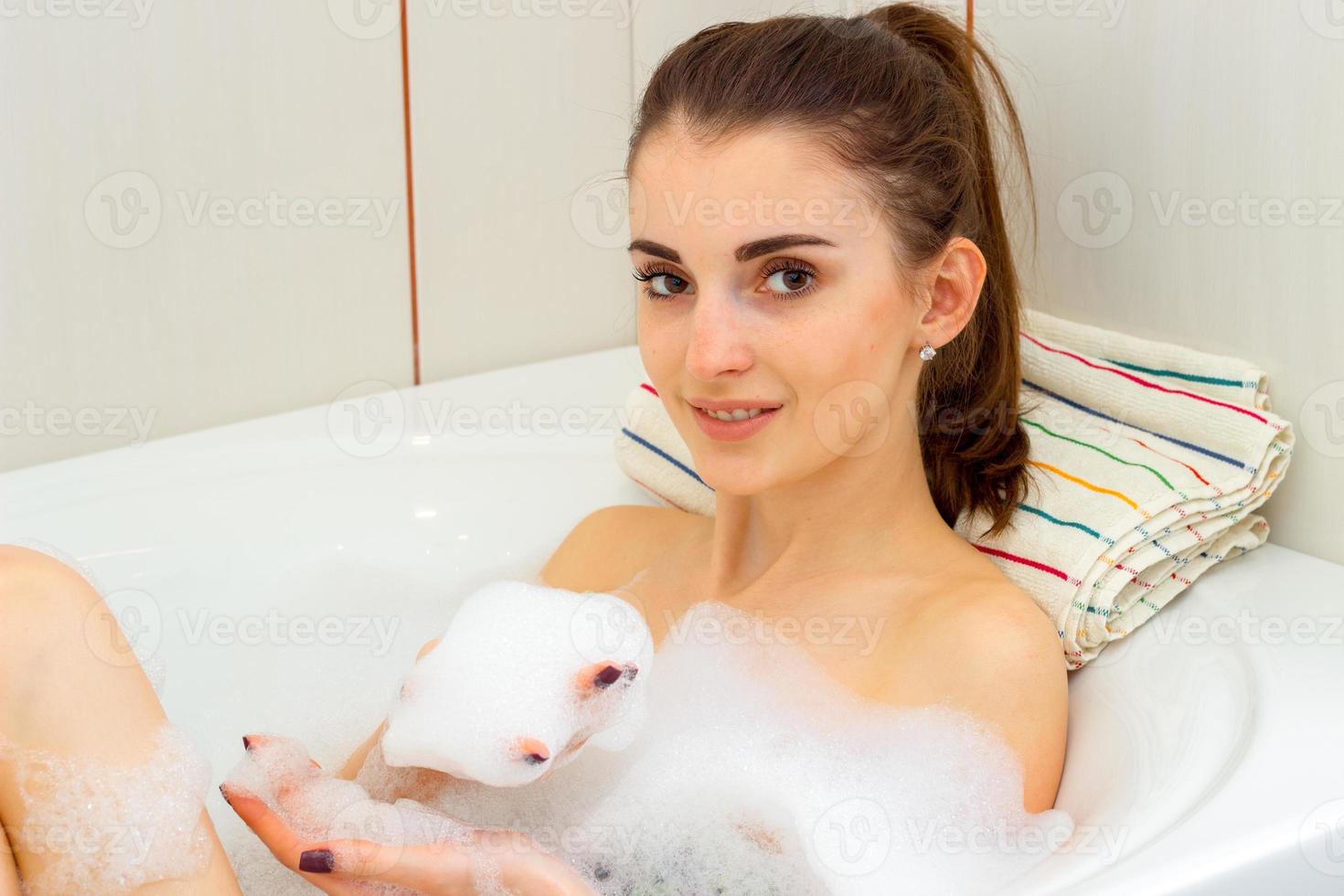 a woman bathes in the bath with foam photo