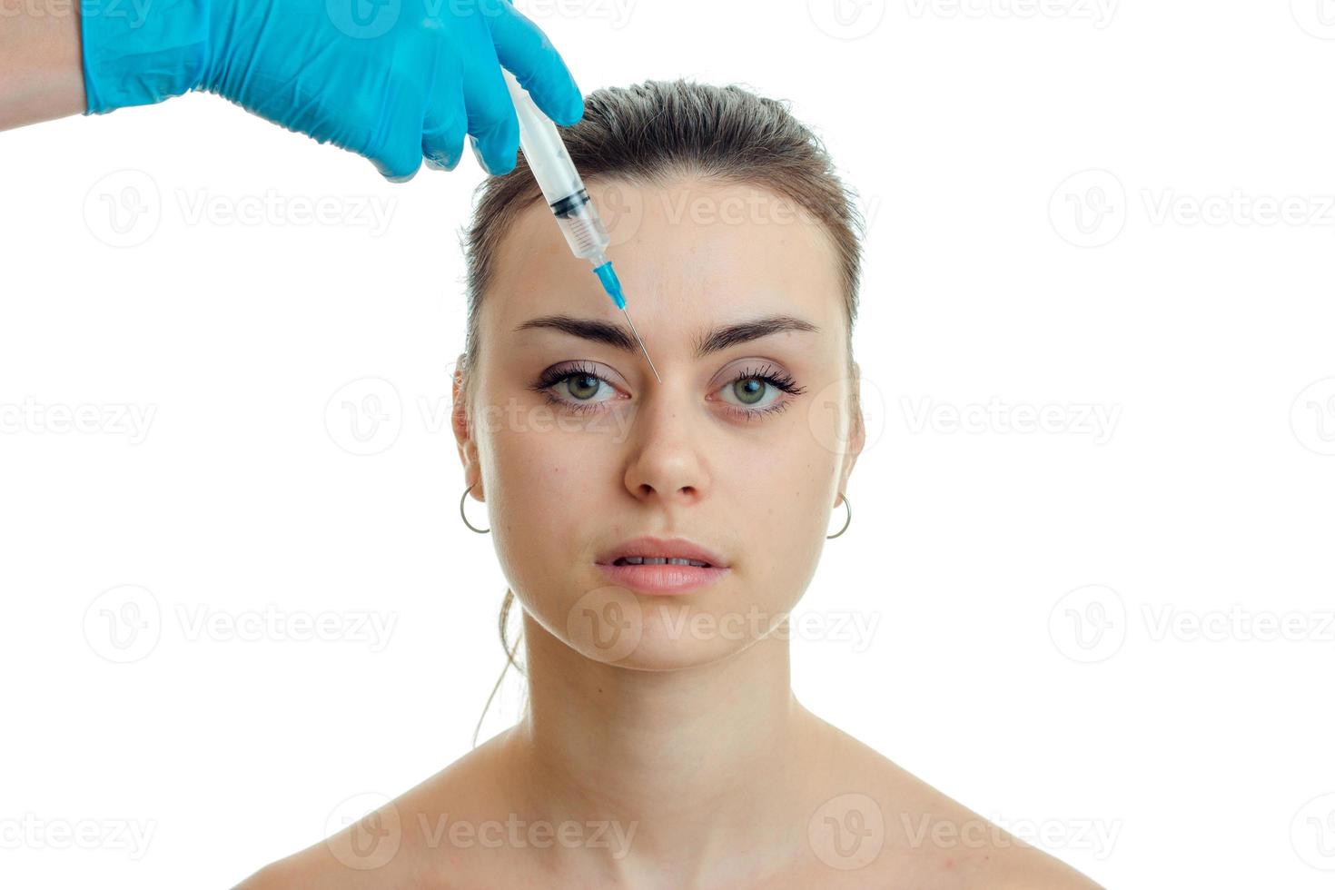 cosmetologist introduces vaccine on face of beautiful young female isolated on a white background photo