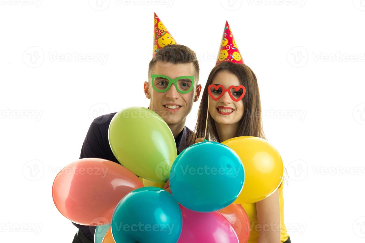 smiling beautiful young couple in coloured glasses held multicolored balloons photo