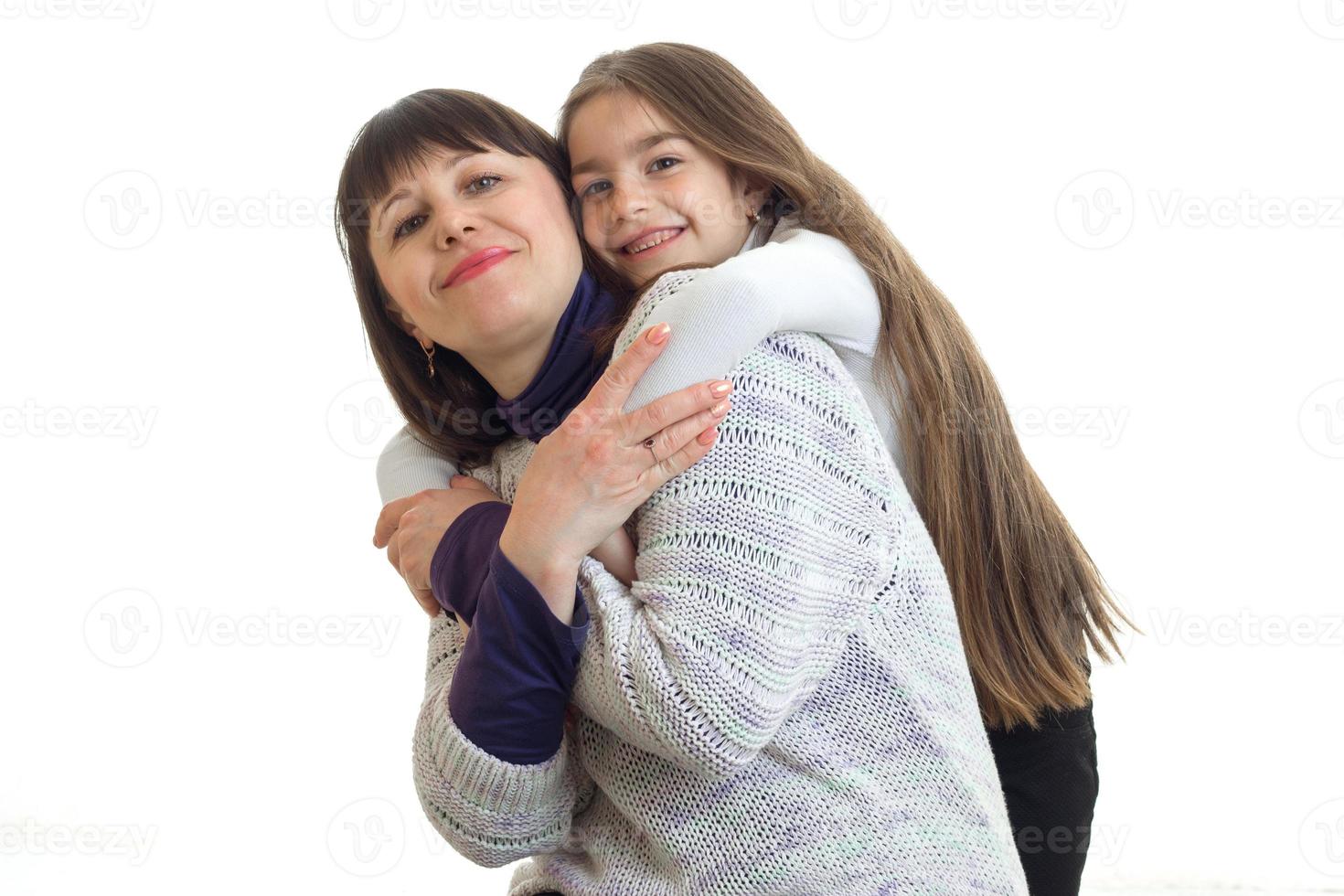 Mother with little daughter hugs in studio photo